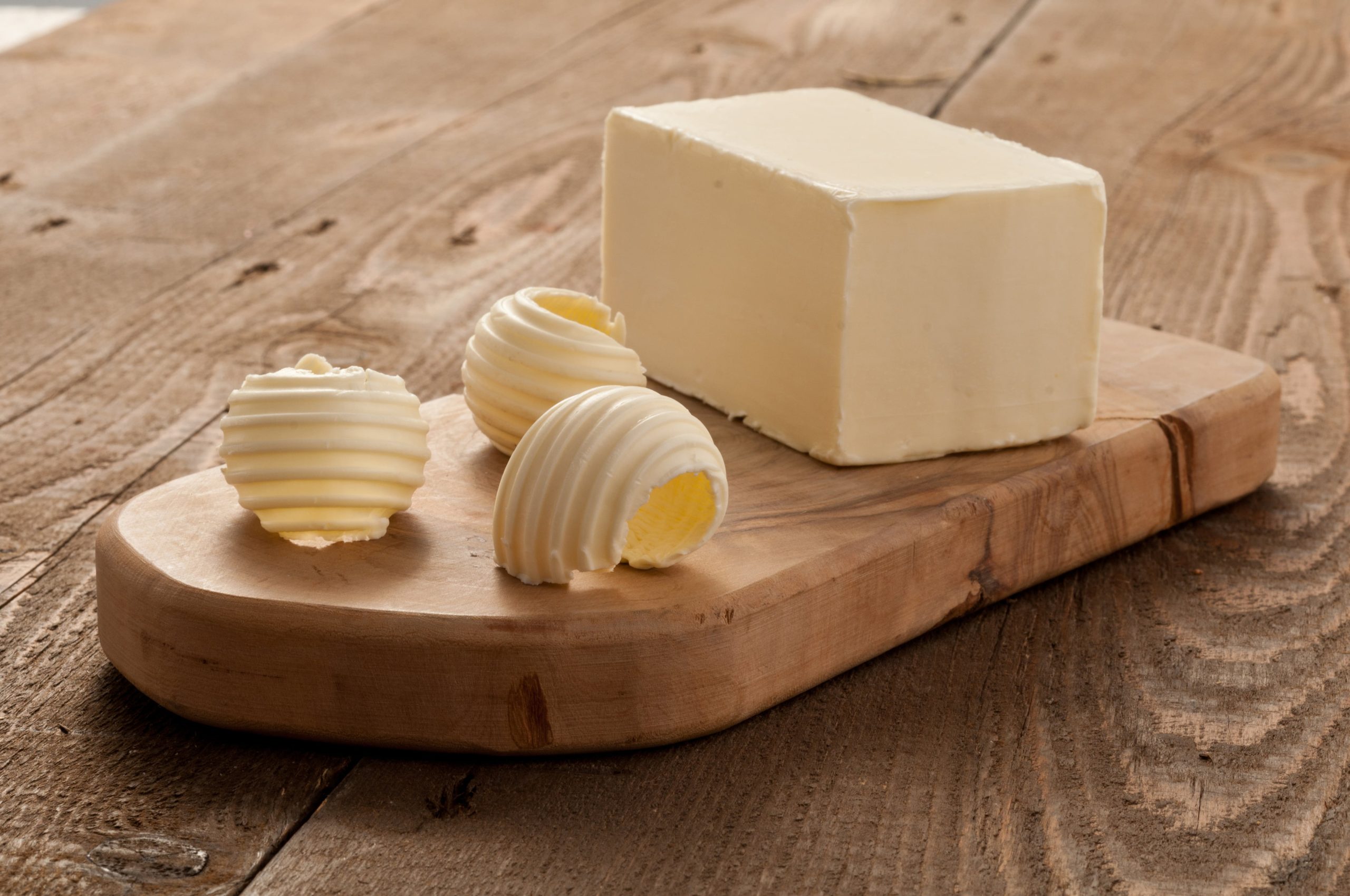 photo d'une plaquette de beurre, matière grasse, posée sur une planche en bois