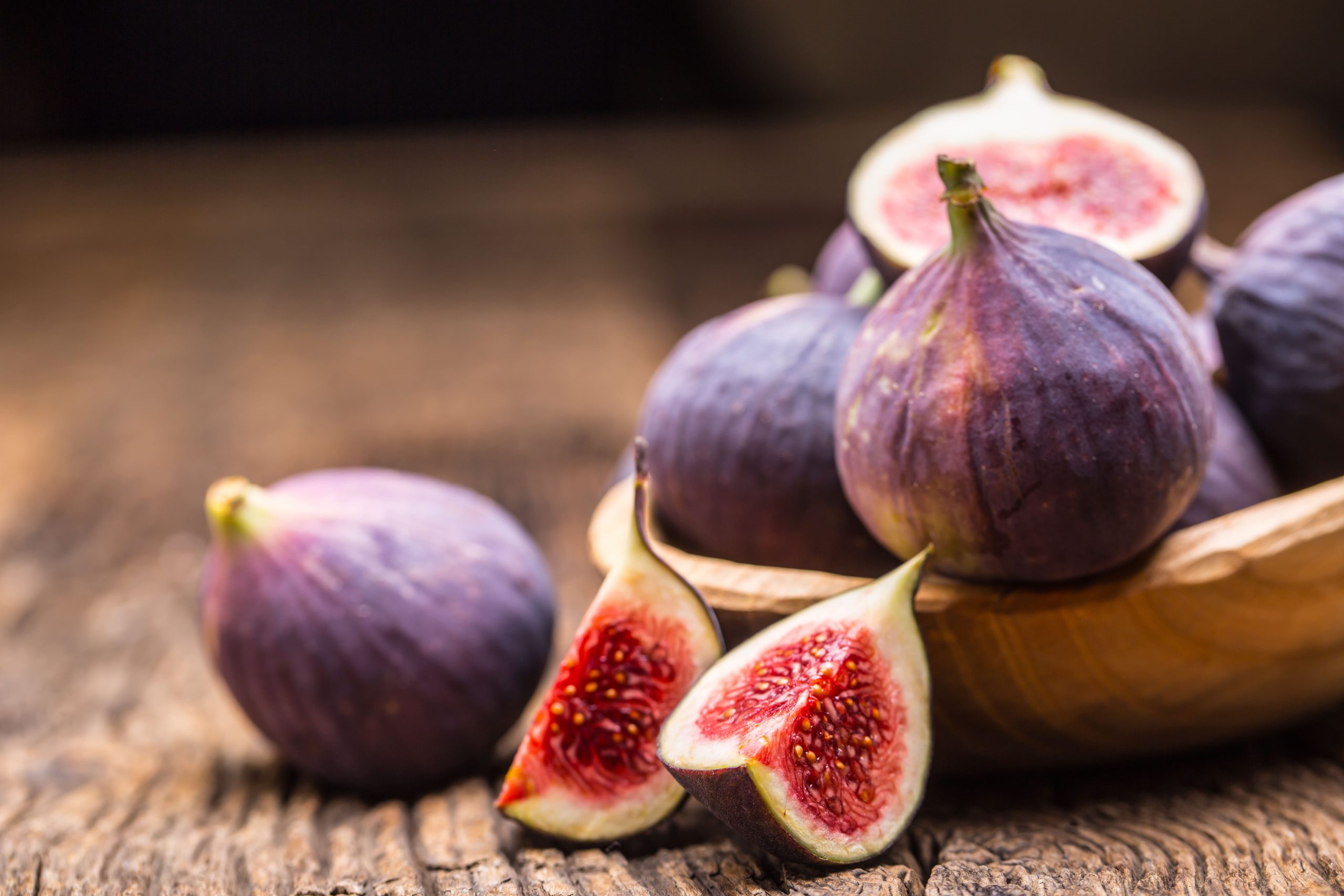 photo de figues posées sur une table et d'une figue coupée